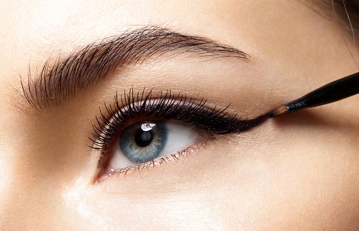 A woman applying eyeliner to her eyelids