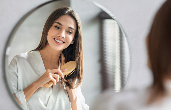 Woman combing smooth hair by using leave-in conditioners