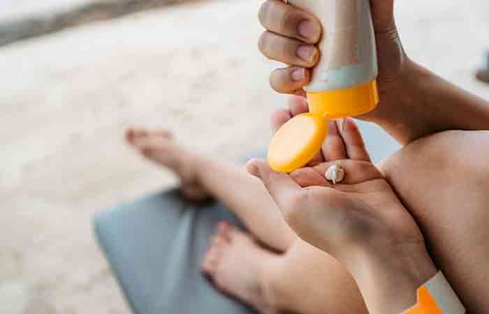 Woman applying sunscreen containing silicones on the beach